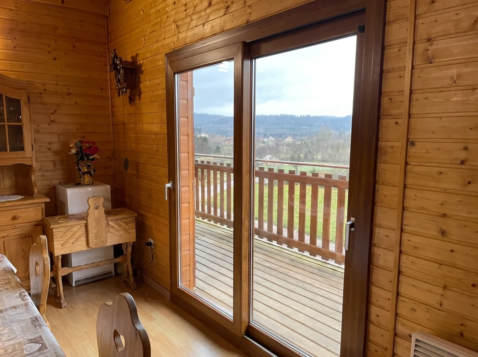 Intérieur chalet en bois avec vue sur balcon terrasse