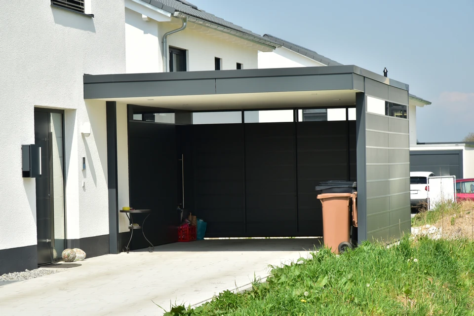 Façade extérieure d'une maison avec porte de garage sectionnelle en acier, coloris anthracite RAL 7016, à lames horizontales lisses