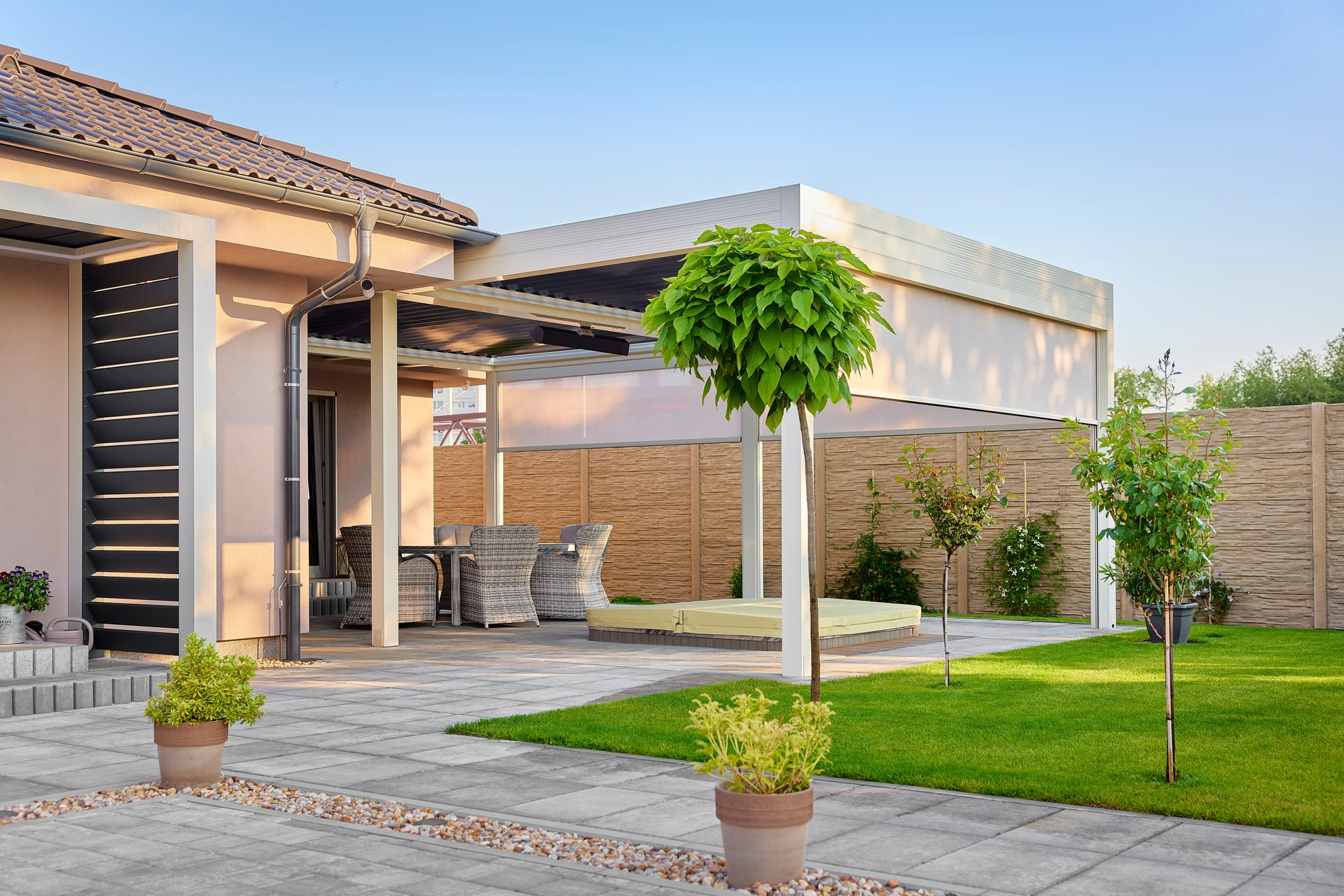 Porte d'entrée aluminium anthracite RAL 7016 installée en façade blanche. Monobloc avec trois vitrages rectangulaires dépolis horizontaux, cinq inserts horizontaux en inox brossé entre les vitrages, poignée levier inox sur rosace, serrure multipoints, encadrement en feuillure maçonnée. Photo de face, lumière naturelle.